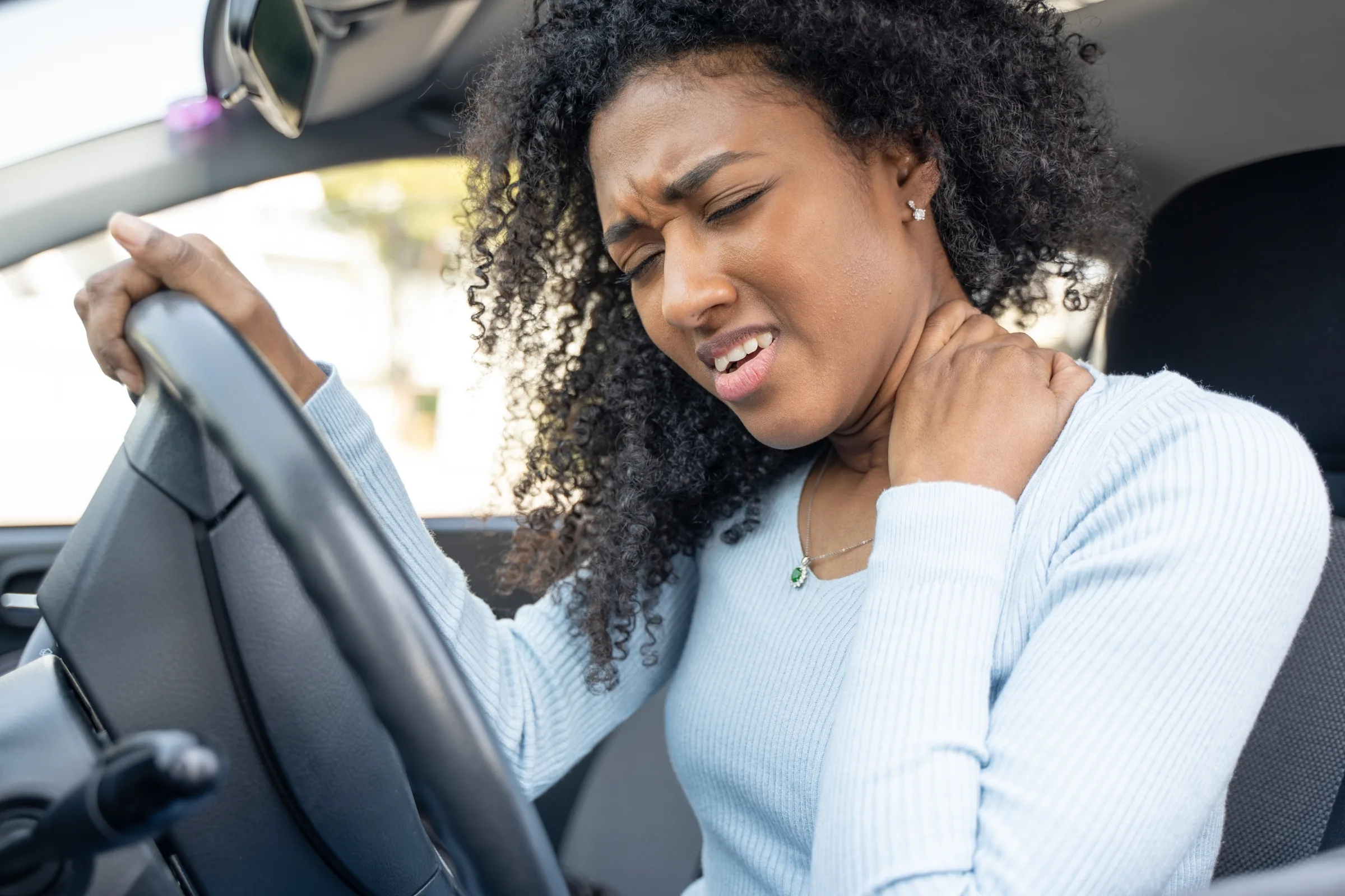 A driver holding her neck after a collision in Ocala
